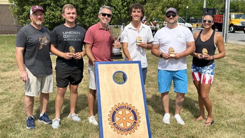 Winners of the Cornhole Madness Tournament posing with the trophy.