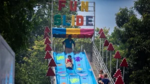 Children riding down a big slide at the Good Neighbor Day carnival.