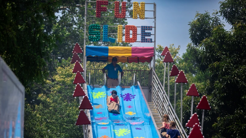 Children riding down a big slide at the Good Neighbor Day carnival.
